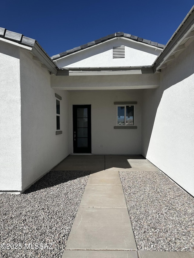 doorway to property featuring a patio and stucco siding