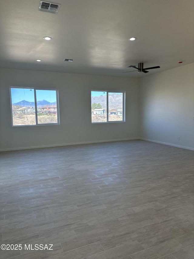 empty room with recessed lighting, baseboards, visible vents, and a healthy amount of sunlight