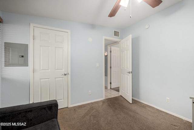 unfurnished bedroom featuring visible vents, carpet floors, baseboards, ceiling fan, and electric panel