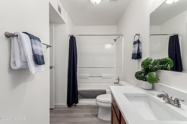 full bath featuring visible vents, wood finished floors, vanity, baseboards, and toilet