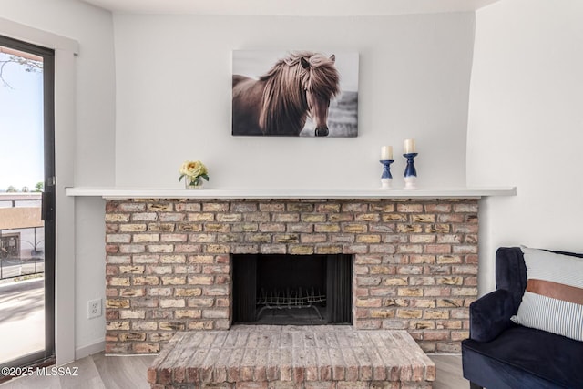 room details with a brick fireplace and wood finished floors