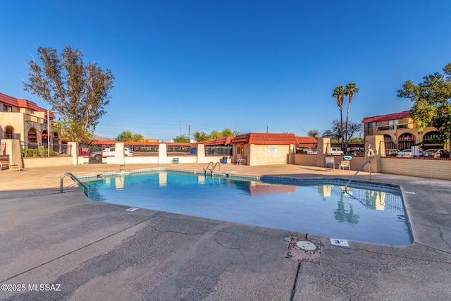 pool with fence and a patio
