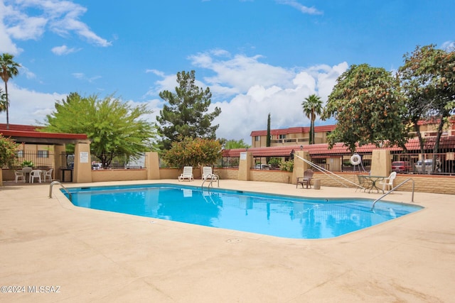 community pool featuring a patio and fence