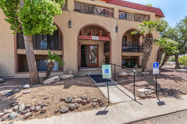 view of exterior entry with stucco siding and a tile roof