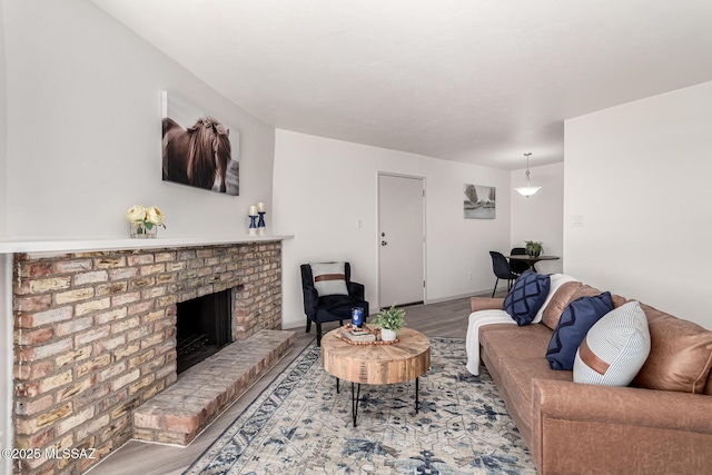 living room featuring a brick fireplace and wood finished floors