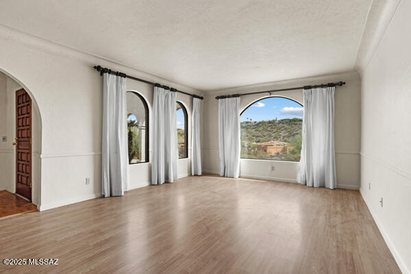 4361 N Wilmot Rd, Tucson, AZ 85750 - unfurnished room with arched walkways and wood finished floors