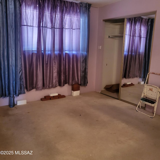 unfurnished bedroom featuring carpet floors and a closet
