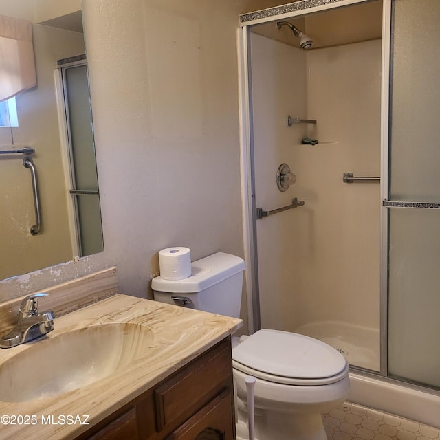bathroom featuring vanity, a shower stall, and toilet