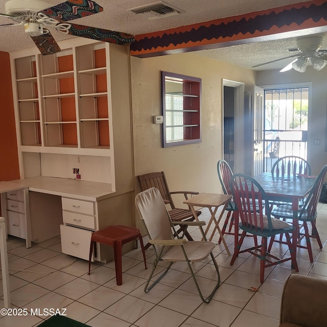 dining space featuring ceiling fan, light tile patterned flooring, a textured ceiling, and visible vents