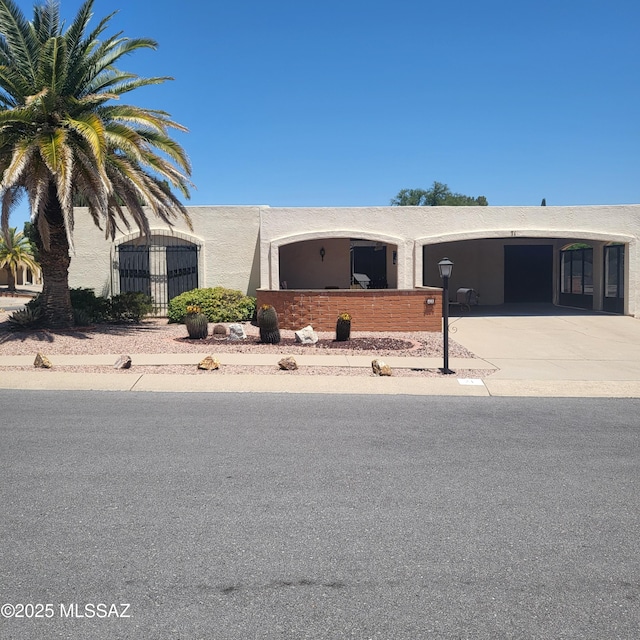 ranch-style home with stucco siding and concrete driveway