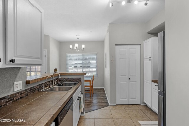 1500 E Pusch Wilderness Dr Unit 10105, Oro Valley, AZ 85737 - kitchen featuring dishwasher, a sink, white cabinets, decorative backsplash, and tile counters