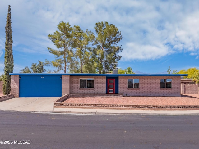 7555 E 25th St, Tucson, AZ 85710 - view of front of property featuring brick siding, a garage, and concrete driveway