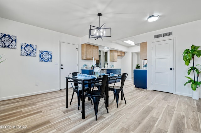 7555 E 25th St, Tucson, AZ 85710 - dining room featuring baseboards, light wood finished floors, a chandelier, and visible vents