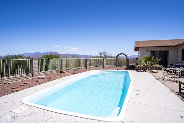 view of pool with a fenced in pool, a mountain view, a patio, and fence