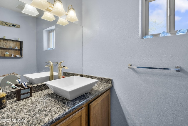 bathroom with vanity and a textured wall