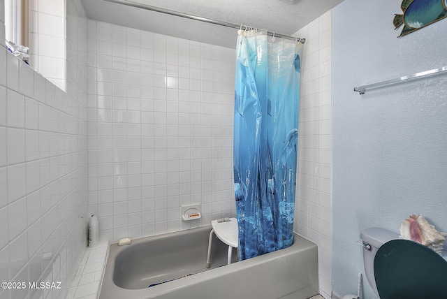 bathroom with shower / bath combo with shower curtain, a textured ceiling, and toilet