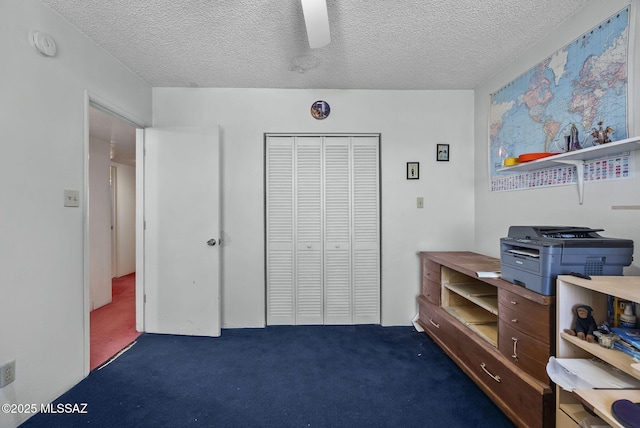 carpeted bedroom with ceiling fan, a closet, and a textured ceiling
