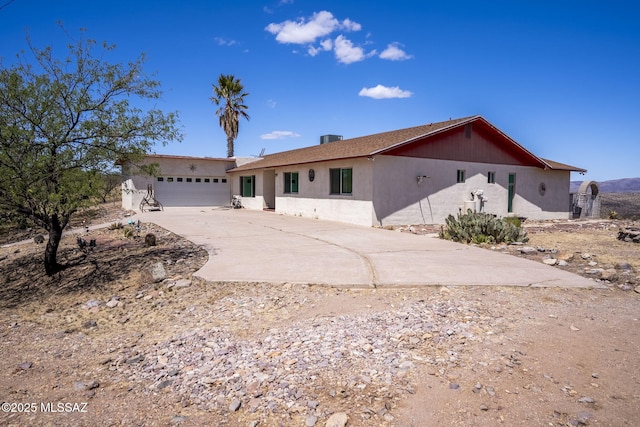 single story home with an attached garage, stucco siding, and driveway