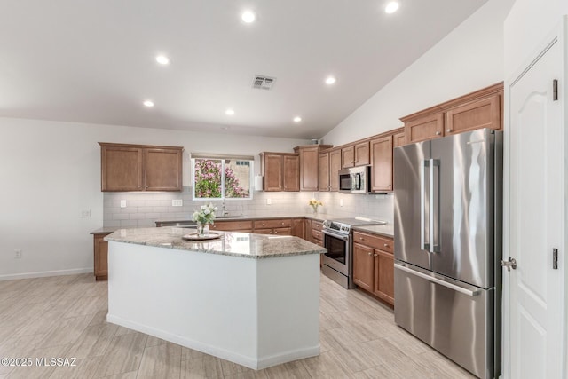 13795 N Buckhorn Cholla Dr, Marana, AZ 85658 - kitchen with appliances with stainless steel finishes, a center island, brown cabinetry, decorative backsplash, and recessed lighting