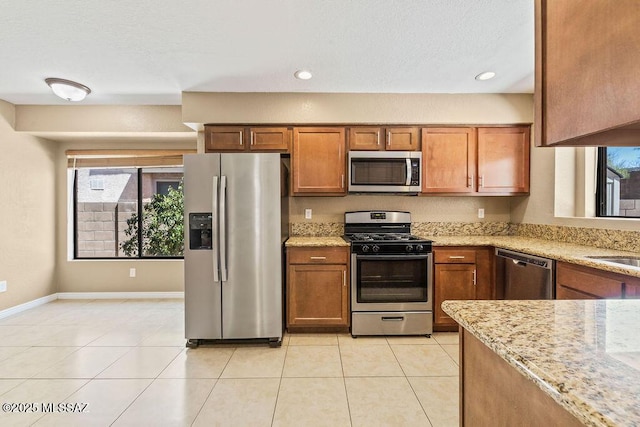 kitchen featuring brown cabinetry, plenty of natural light, and appliances with stainless steel finishes