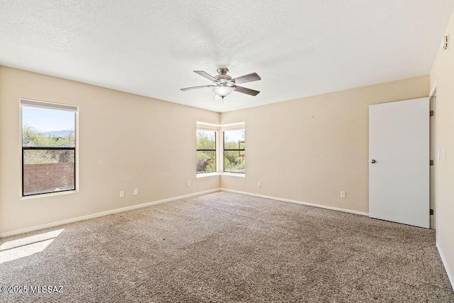 spare room featuring a ceiling fan, a textured ceiling, baseboards, and carpet floors