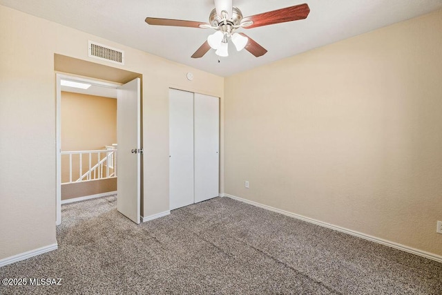 unfurnished bedroom featuring carpet flooring, baseboards, a closet, and visible vents