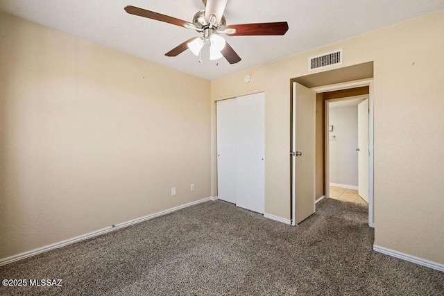 unfurnished bedroom featuring a closet, visible vents, ceiling fan, carpet floors, and baseboards