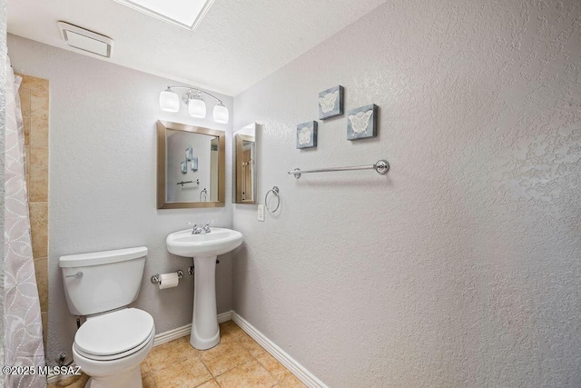 bathroom with toilet, curtained shower, baseboards, and tile patterned flooring