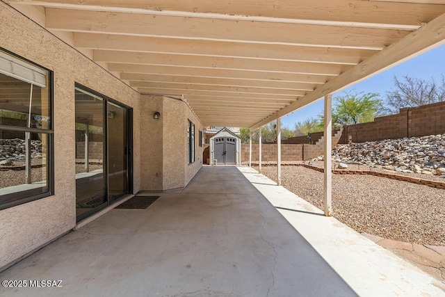 view of patio featuring a fenced backyard, an outdoor structure, and a storage shed