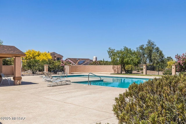 view of swimming pool featuring a patio, fence, and a fenced in pool