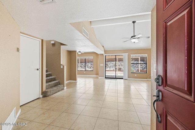 entryway featuring ceiling fan, light tile patterned flooring, a wealth of natural light, and visible vents