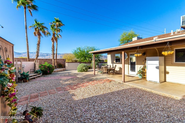 view of yard with a patio, a fenced backyard, and a mountain view