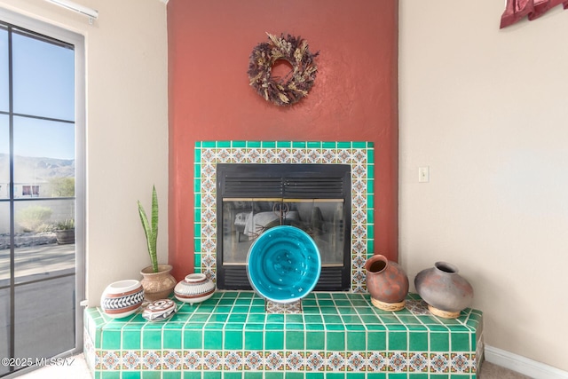 room details with baseboards and a tile fireplace
