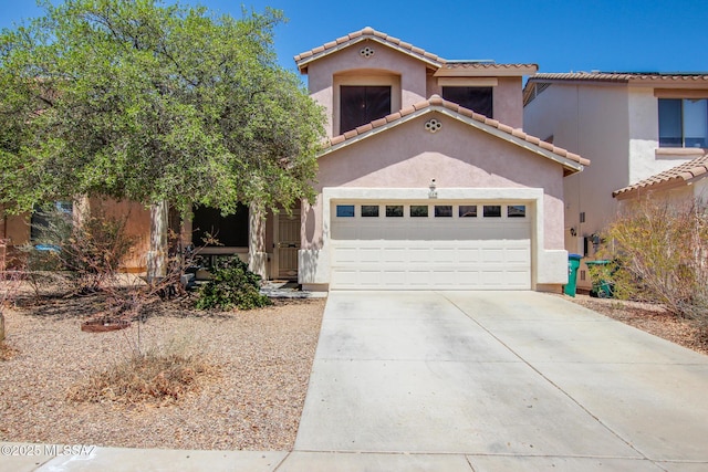 mediterranean / spanish house featuring an attached garage, stucco siding, concrete driveway, and a tiled roof