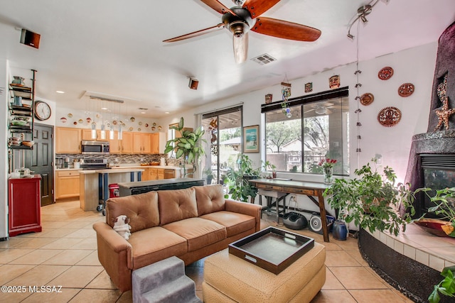 living room featuring ceiling fan, light tile patterned flooring, and visible vents