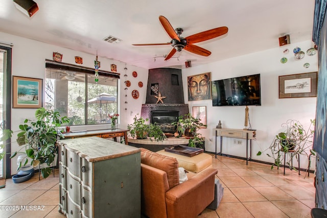 living room featuring visible vents, ceiling fan, light tile patterned flooring, and a large fireplace