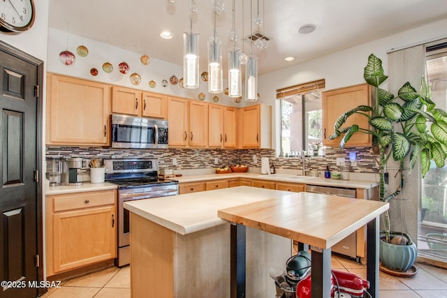 kitchen with light tile patterned flooring, a sink, light brown cabinets, stainless steel appliances, and decorative backsplash