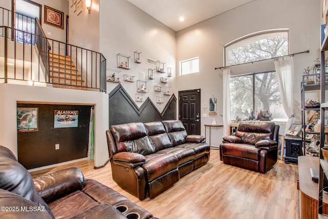 living room with stairs, a high ceiling, and wood finished floors
