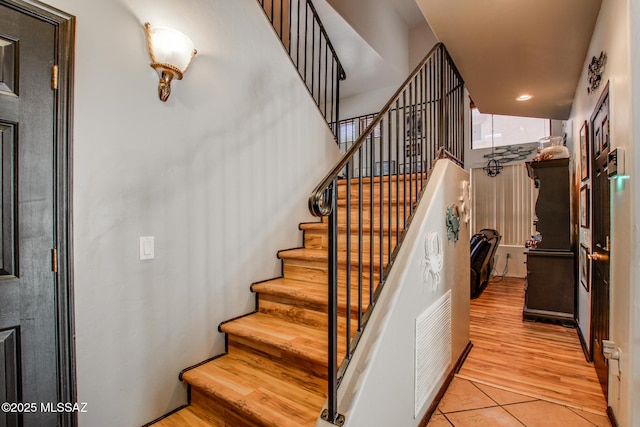 staircase featuring visible vents and tile patterned flooring