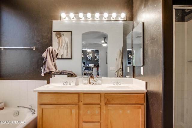 ensuite bathroom with a sink, ensuite bathroom, a ceiling fan, and double vanity