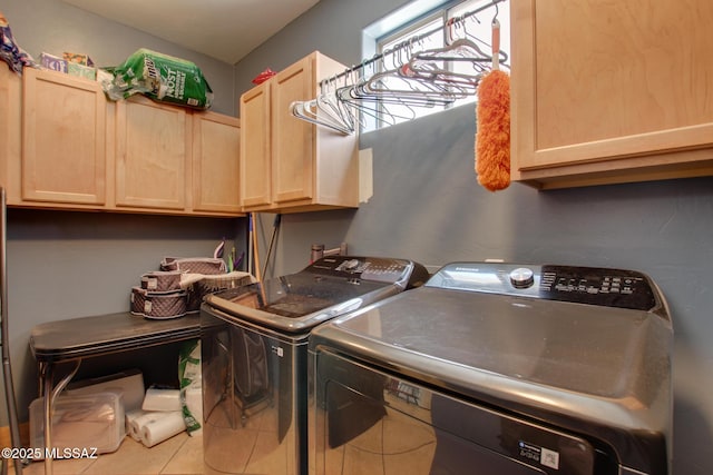 laundry room featuring cabinet space, washing machine and dryer, and tile patterned flooring