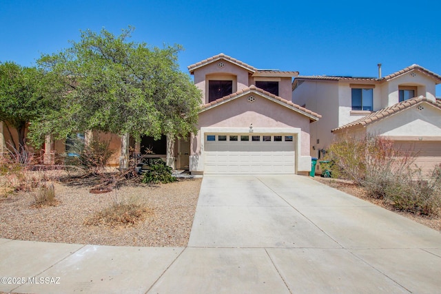 view of front of property with stucco siding, concrete driveway, and a tiled roof