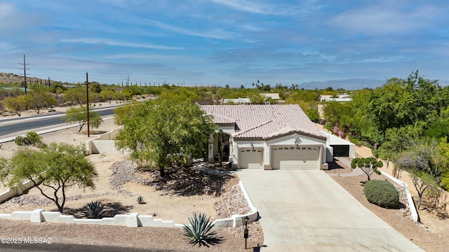 single story home with an attached garage, stucco siding, a tiled roof, and concrete driveway