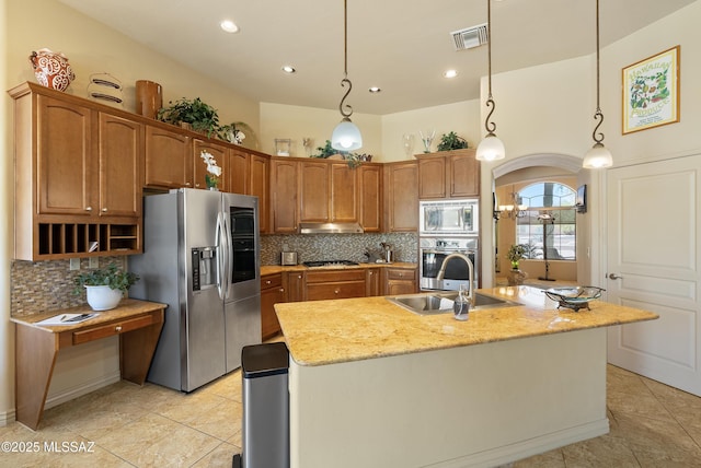 kitchen featuring light tile patterned floors, appliances with stainless steel finishes, a sink, and tasteful backsplash
