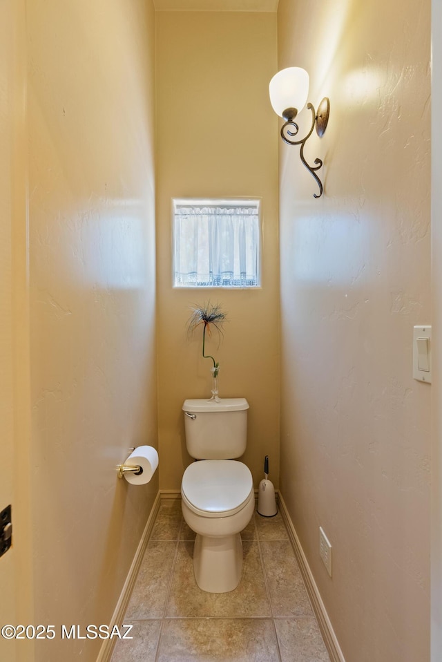 bathroom featuring tile patterned floors, baseboards, and toilet