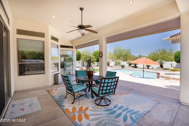 view of patio featuring a ceiling fan, outdoor dining area, and a pool with connected hot tub