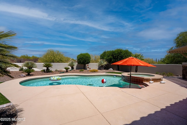 view of pool with a pool with connected hot tub, a fenced backyard, and a patio area