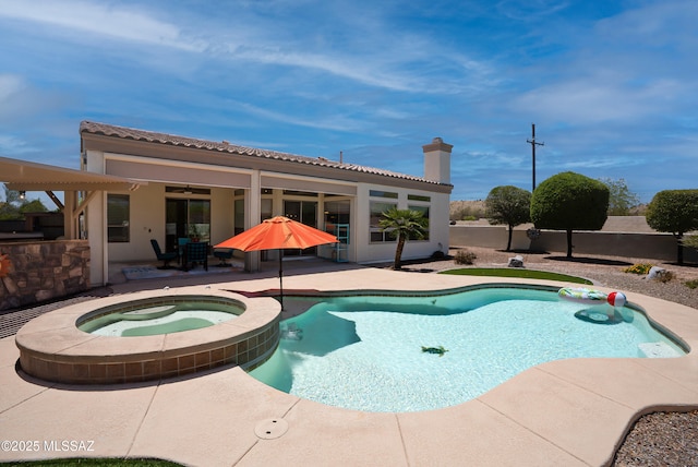 view of swimming pool with ceiling fan, a patio area, and a pool with connected hot tub