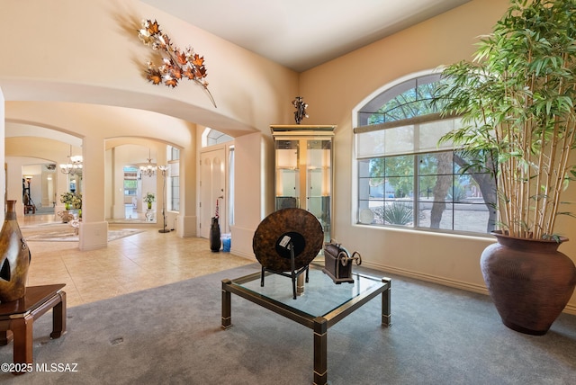 living area featuring arched walkways, baseboards, carpet flooring, and lofted ceiling