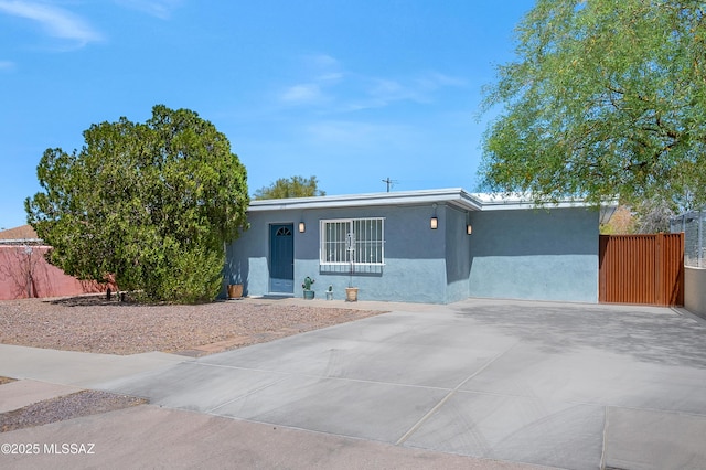 215 E Lester St, Tucson, AZ 85705 - view of front of property with fence, stucco siding, and concrete driveway
